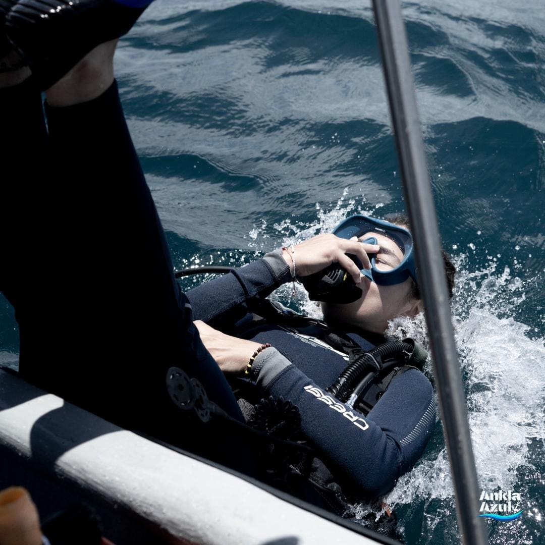 Student diver performing a backward roll entry from a boat into the water at Ankla Azu